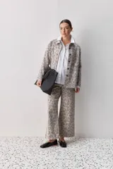Pantalón de jean tiro medio con corte wide leg y estampado animal print. Presenta costuras verticales frontales y diseño de pierna amplia.