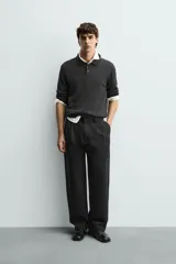 Pantalón de corte wide fit confeccionado en tejido con mezcla de lyocell. Presenta pliegues frontales dobles, bolsillos laterales y bolsillos traseros de vivo. Cierre frontal con cremallera y gancho metálico oculto.