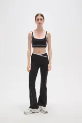 Top deportivo negro con detalles de ribete blanco en el escote y breteles. Presenta un diseño de corte cuadrado y ajuste al cuerpo.