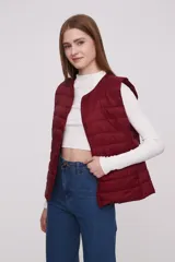 Chaleco acolchado color borgoña, con cuello redondo y cierre frontal con botones a presión.