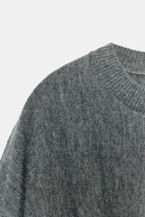 Jersey de punto color gris, con cuello redondo, manga larga y detalle de cintura ajustada con tejido tipo nido de abeja.