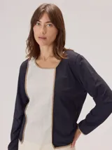 Remera de manga larga en color negro, con diseño de cuello redondo y terminaciones con vivos en contraste color beige. Presenta un corte recto y minimalista.