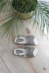 Sandalias bajas color verde oliva, con dos tiras anchas cruzadas sobre el empeine y tira trasera con hebilla.