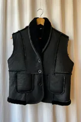 Chaleco negro de cuero genuino con interior de piel sintética, cierre frontal con botones y bolsillos delanteros. Hecho en Uruguay.