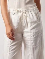 Pantalón palazzo color crudo de lyocell marca Nanette, con pretina elastizada, lazo de ajuste y bolsillos delanteros.