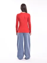 Remera de manga larga color rojo, con estampa frontal abstracta en color blanco que representa un rostro.