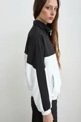 Campera estilo aviador de tela avión, en diseño bicolor negro y blanco, con cierre frontal y cuello alto. Cuenta con bolsillos laterales con cierre y bordado de la marca Mandinga en el pecho.