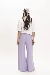 Pantalón de corte palazzo color lila, con cintura alta y bolsillos laterales.