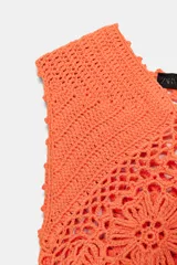 Top tejido al crochet color naranja, con escote en V y diseño calado con motivos florales.