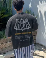 Remera blanca de manga corta, corte regular y cuello redondo, con gran estampado en la espalda de temática "Worldwide Tour" con una calavera y texto en rojo, azul y blanco.