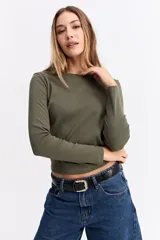 Remera de manga larga con cuello redondo y ajuste al cuerpo, confeccionada en tejido de algodón con textura acanalada.