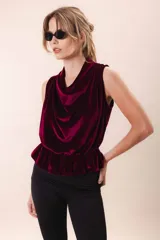 Blusa de terciopelo color borgoña, sin mangas, con escote drapeado y peplum elastizado en la cintura.