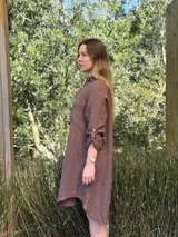 Vestido camisero color beige claro, de lino 100% natural, con botones de nácar, bolsillo delantero y mangas 3/4 con botón para recogerlas. Diseño asimétrico, más largo en la parte trasera.