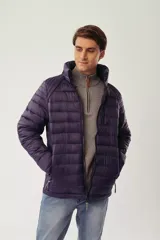 Campera puffer de diseño acolchado en color azul oscuro, con cuello elevado, cierre frontal completo y bolsillos laterales con cierre. Incluye un bolsillo adicional en el pecho y capucha oculta.