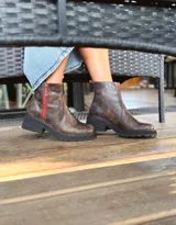 Botas cortas de cuero color chocolate, con elástico lateral, cierre interno con cremallera roja, pespuntes rojos y suela track.