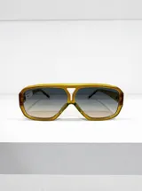Lentes de sol con armazón geométrico de policarbonato color amarillo traslúcido y cristales degradé con protección UV.
