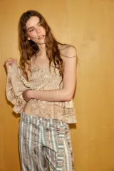 Pantalón bombacho de tiro medio con estampado de rayas verticales en tonos tierra y beige. Presenta aplicación de lentejuelas, cinturón del mismo tejido, forro interior tipo shorts y bajo acabado en puño con lazada. Cierre lateral con cremallera oculta.