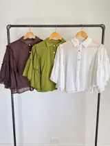 Blusa verde militar de algodón, con mangas amplias estilo campana con volados y diseño liviano.