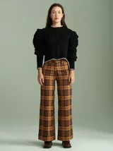 Cardigan negro de algodón con cierre frontal doble, cuello a la base y mangas tipo jamón con bordados en ochos y apliques de pompones. Presenta terminaciones acanaladas en contraste en cuello, puños y ruedo.