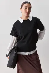 Remera de manga corta negra de algodón, con silueta relajada, cuello redondo y tajos laterales.