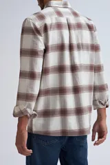 Camisa de manga larga con estampado de cuadros en tonos beige y marrón, confeccionada con cierre frontal de botones y bolsillos en el pecho.
