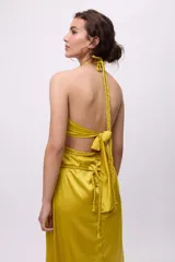 Vestido midi amarillo de satén con escote halter, trenzas en cuello y cintura, cut-outs laterales y falda recta.