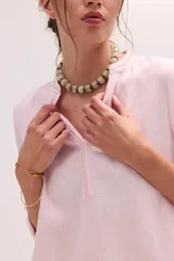 Blusa de lino color marrón con cuello mao, escote en V y mangas largas.