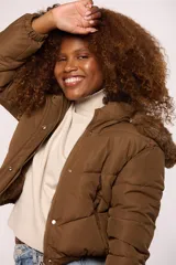Campera bomber de nylon color rosado, con diseño acolchado, cierre frontal con cremallera y botones a presión, y capucha con borde de piel sintética al tono.
