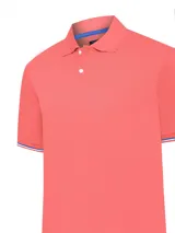 Chomba color salmón de piqué de algodón Pima, con cuello polo, tapeta de dos botones y mangas cortas con puños acanalados con rayas en azul y blanco.