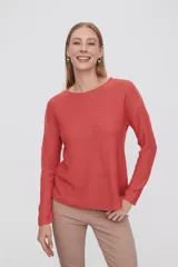 Sweater de punto color crudo, con cuello redondo y mangas largas.