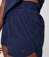 Bermuda deportiva Get Over modelo runner color beige, con cintura elástica, bajo redondeado y aberturas laterales. Cuenta con un pequeño bolsillo funcional trasero.