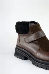 Bota corta de cuero marrón con puntera de gamuza, cuello de piel sintética negra, cierre con velcro y suela track negra.