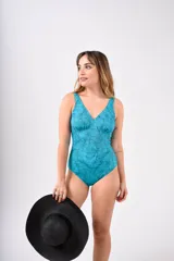 Malla enteriza de lycra con protección UV 50 y forro interior. Presenta un estampado tipo ikat en tonos verde oscuro y beige, con escote en V profundo y fruncido cruzado en la zona del busto.