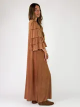 Vestido largo negro de corte holgado, con escote en V y mangas largas con volados en los puños.