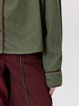 Camisa western de algodón grueso color verde militar, con corte holgado y aplicaciones de hilo en contraste en el pecho, la cartera de botones y los puños.