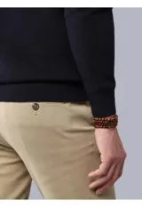 Sweater de punto color azul marino, con cuello alto y cierre frontal parcial de botones. Presenta puños y ruedo acanalados.