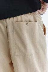 Pantalón en punto de mezcla de algodón, color beige, de corte regular y piernas rectas. Cuenta con cintura elástica con cordón ajustable, bolsillos laterales al bies y bolsillos traseros de parche.