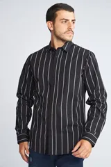 Camisa de manga larga con cuello clásico y cierre frontal abotonado. Presenta un estampado de cuadros en tonos azul marino y rojo. Confeccionada en algodón, cuenta con un corte slim fit y logo bordado en el pecho.