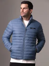 Campera acolchada azul con cuello alto, cierre frontal con cremallera y bolsillos laterales.