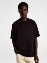 Camiseta de manga corta en tejido de punto texturizado con diseño de rayas verticales sutiles, cuello redondo y corte holgado.