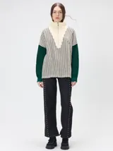 Pullover de tejido acanalado grueso con diseño bicolor en tonos marrón y bordó. Presenta cuello alto con cierre frontal, mangas largas y corte holgado.