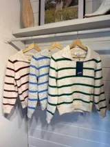 Sweater de punto con diseño a rayas horizontales en color gris y verde. Presenta cuello tipo polo con escote en V, mangas largas y puños acanalados.