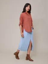 Falda midi de jean azul claro con corte en el centro del frente.