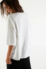 Remera de algodón muy suave, de calce oversize y silueta recta, con escote redondo y mangas cortas de hombro caído.