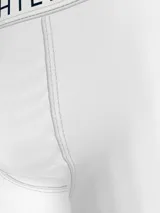 Pack de tres calzoncillos tipo trunk de Tommy Hilfiger, confeccionados en algodón elástico. Incluye un modelo blanco, uno negro y uno gris melange, todos con cintura elástica con el nombre de la marca estampado.