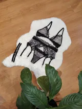 Conjunto de lencería compuesto por bralette triangular y bombacha tipo colaless, confeccionados en microtul estampado con detalles de encaje negro. Incluye portaligas desmontable con tiras ajustables.