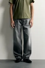 Jeans de denim de algodón en color azul con efecto desgastado, tiro medio y corte recto de ajuste holgado (loose fit). Cuenta con diseño clásico de cinco bolsillos y cierre frontal con cremallera y botón.