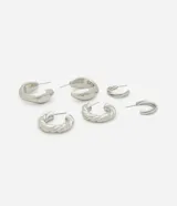 Kit de tres pares de argollas metálicas con diferentes acabados: una lisa, una tipo croissant y una con diseño trenzado en relieve.