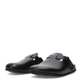 Zueco negro de mujer con suela de goma negra y plantilla de corcho. Presenta una tira ancha ajustable con hebilla metálica sobre el empeine.