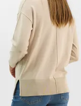 Buzo de tejido fino color amarillo, con cuello redondo, manga larga con puños acanalados y pespunte central vertical en el frente y la espalda. Presenta un ruedo ancho acanalado con tajos laterales.